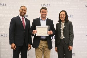 Prof. Avi Schroeder receiving the AIMBE fellowship from the hands of AIMBE College of Fellows Chair Prof. Guillermo Ameer and AIMBE President Prof. Joyce Wong.